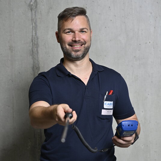 Techniker, der Messgerät in die Kamera hält